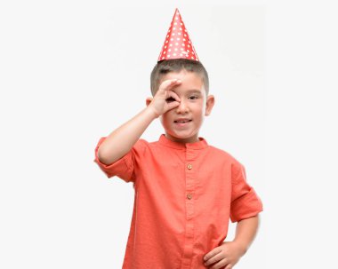 Koyu saçlı küçük çocuk mutlu yüz el parmaklarının arasından seyir göz üzerinde ok işaretiyle yapıyor gülümseyen ile Doğum günü şapkası