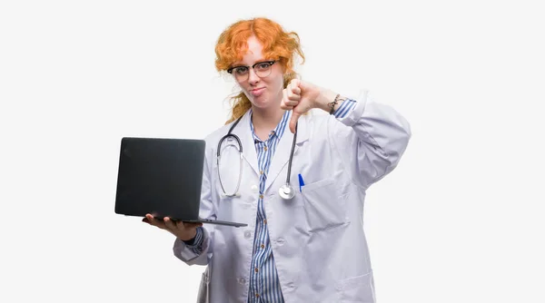 Jovem Mulher Médica Ruiva Segurando Laptop Computador Com Rosto Irritado — Fotografia de Stock