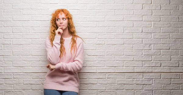 Mujer Pelirroja Joven Pie Sobre Pared Ladrillo Con Mano Barbilla — Foto de Stock