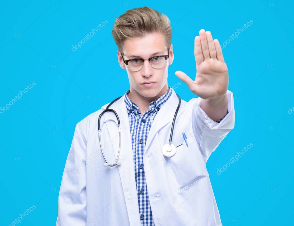 Young handsome blond doctor with open hand doing stop sign with serious and confident expression, defense gesture