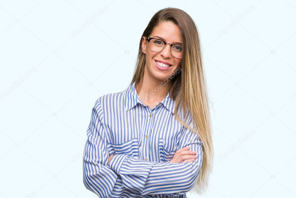 Beautiful young woman wearing elegant shirt and glasses happy face smiling with crossed arms looking at the camera. Positive person.