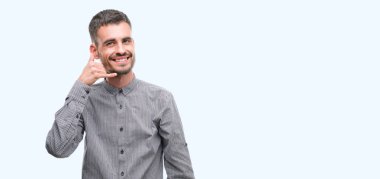 İşin gülümseyen genç hipster adam telefon hareketi ile el ve parmak telefonda konuşuyor gibi. Kavramları iletişim.