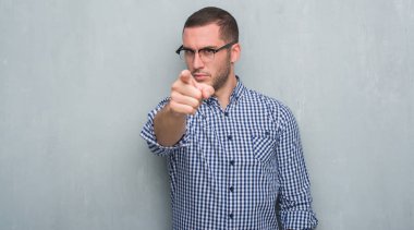 Kamera ve size parmak ile işaret gri grunge duvarın üzerinden Genç beyaz iş adamı, el işareti, pozitif ve kendinden emin bir jest ön