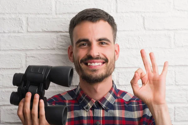 Ung Vuxen Man Över Tegelvägg Tittar Genom Kikaren Gör Tecken — Stockfoto