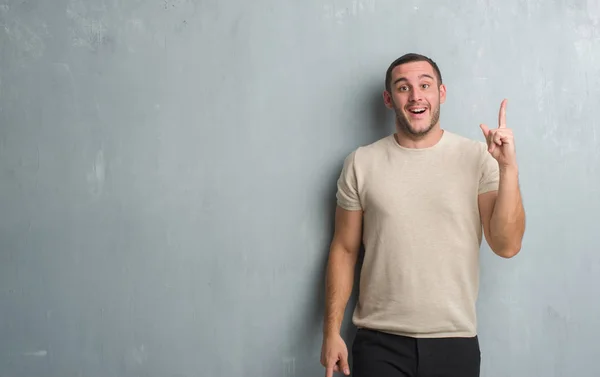 Joven Hombre Caucásico Sobre Una Pared Gris Apuntando Con Dedo — Foto de Stock