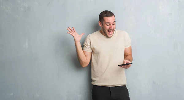 Joven Caucásico Hombre Sobre Gris Grunge Pared Mensajes Texto Mensaje —  Fotos de Stock