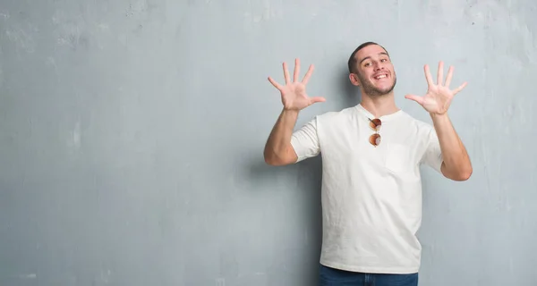 Young Caucasian Man Grey Grunge Wall Wearing Sunglasses Showing Pointing — Stock Photo, Image