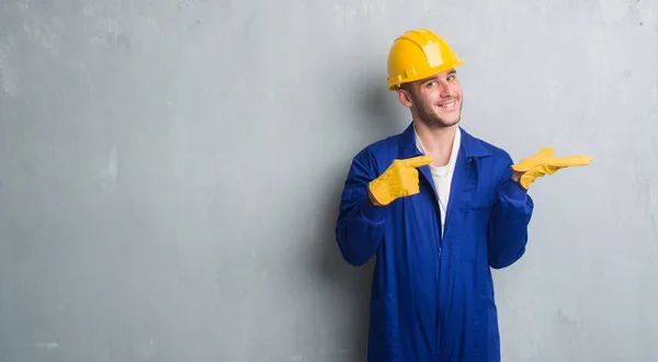 Homem Caucasiano Jovem Sobre Parede Grunge Cinza Vestindo Uniforme Empreiteiro — Fotografia de Stock