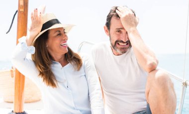 Orta yaş çift elle kafasına, utanç ve sürpriz ile şok vurguladı Yelkenli üzerinde seyahat yüz, öfkeli ve sinirli. Korku ve hata için üzgün.