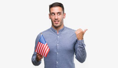 Amerika el ve parmak ile mutlu yüz gülümseyen ile yukarı dönük bir bayrak tutan yakışıklı genç