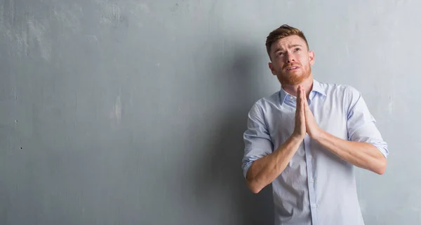 Young Redhead Business Man Grey Grunge Wall Begging Praying Hands — Stock Photo, Image