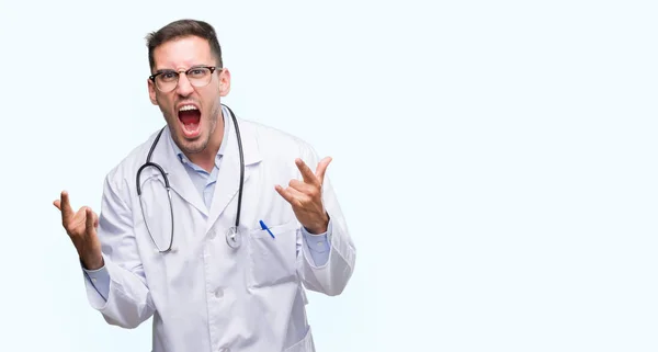 Bonito Jovem Médico Gritando Com Expressão Louca Fazendo Símbolo Rock — Fotografia de Stock