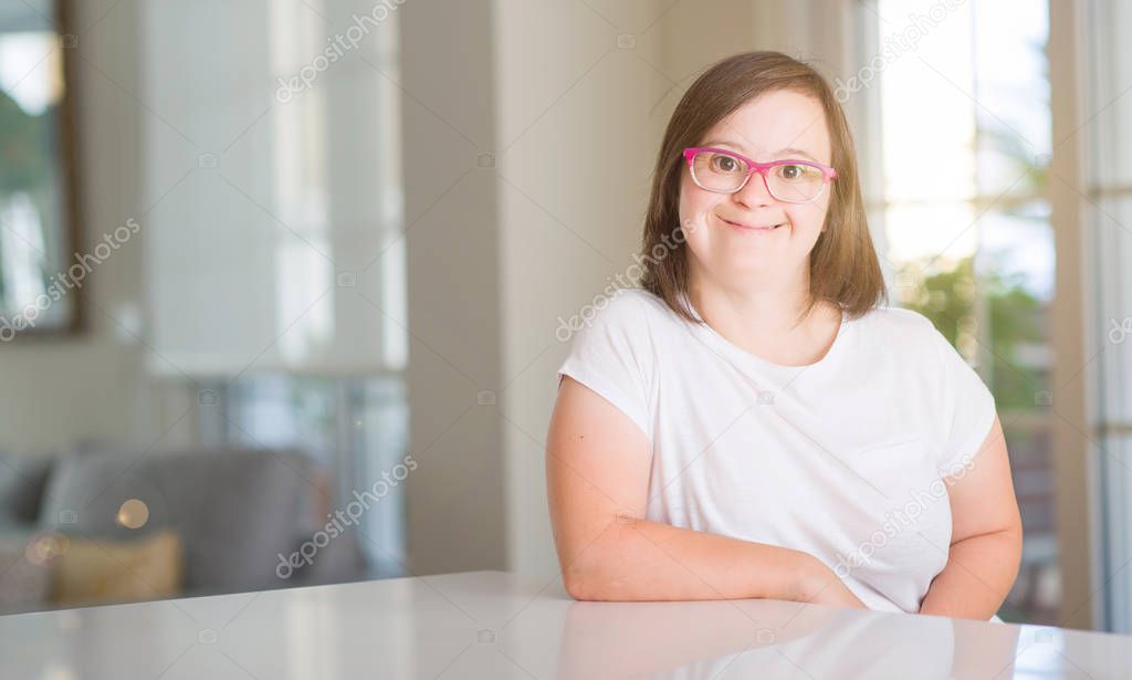 Down syndrome woman at home with a happy face standing and smiling with a confident smile showing teeth
