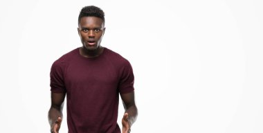 Genç Afro-Amerikan adam şok sürpriz yüzü, korkuyor ve korku ifadesi ile heyecanlı olan korkmuş