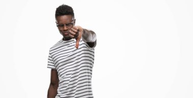 Gözlük ve mutsuz ve kızgın ret gösterilen ve başparmak aşağı hareketi ile negatif seyir lacivert t-shirt giyen genç Afro-Amerikan adam. Kötü ifade.