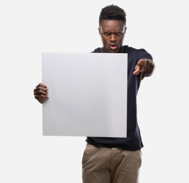 Bir afiş kamera ve size, el işareti, pozitif ve kendinden emin bir jest ön parmak ile işaret tutan genç Afro-Amerikan adam