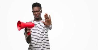 Açık eliyle dur işareti ile ciddi ve kendine güvenen ifade, savunma jest yapıyor megafon tutan genç Afro-Amerikan adam