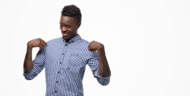 Yüzünde gülümseme ile kendinden emin görünüyorsun, kendini gururlu ve mutlu parmakları ile işaret mavi gömlek giymiş genç Afro-Amerikan adam.