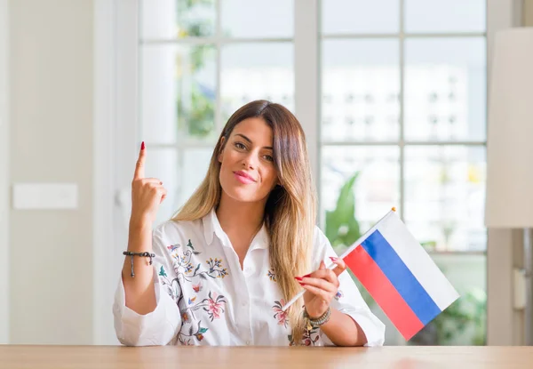 ホーム開催で若い女性のアイデアに驚いてロシア国旗または幸せそうな顔 ナンバーワンと人差し指を質問 — ストック写真