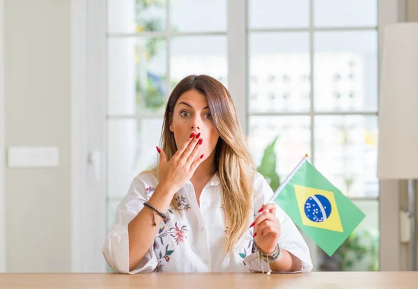 Молодая Женщина Дома Флагом Бразилии Прикрывает Рот Рукой Потрясенной Стыдом — стоковое фото