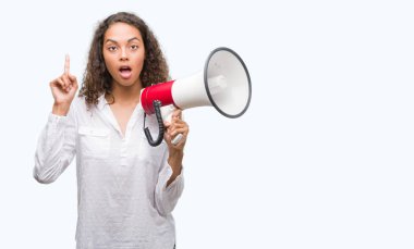 Megafon sürpriz bir fikir ya da soru işaret parmağı ile gülen yüz, bir numara tutan genç İspanyol kadın