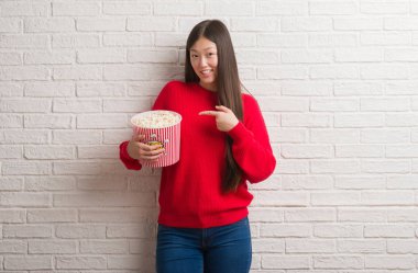 Genç Çinli kadın pop Mısır el ve parmak ile işaret çok mutlu yemek tuğla duvarın üzerinden