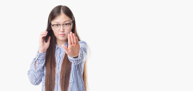 İzole arka plan açık eliyle dur işareti ile ciddi ve kendine güvenen ifade, savunma hareketi yaparken konuşan Genç Çinli kadın