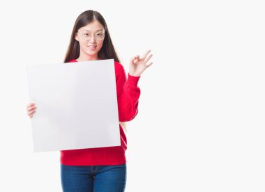 İzole arka plan boş afiş parmak, mükemmel sembolü ile ok işareti yapıyor tutan genç Çinli kadın