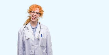 Dilini Doktor üniforması giyen genç Kızıl saçlı kadın out komik ifade ile mutlu. Duygu kavramı.