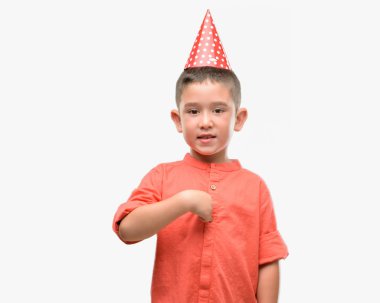 Koyu saçlı küçük çocuk sürpriz yüz işaret parmağı kendisine Doğum günü şapkası
