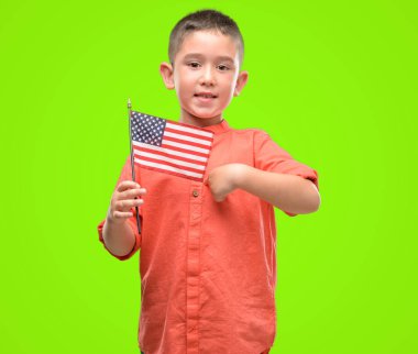 Koyu saçlı küçük çocuk Amerika Birleşik Devletleri bayrağı sürpriz yüz işaret parmağı kendisine holding