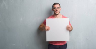 Kendinden emin bir ifade ile boş bir başlık ciddi düşünme acımak yüz tutan gri grunge duvarın üzerinden beyaz delikanlı