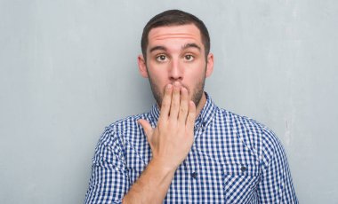 Gri grunge duvar kapağı ağız için hata, ifade korku, utanç ile şok el ile üzerine beyaz delikanlı sessizlik içinde gizli kavramı korkuttu