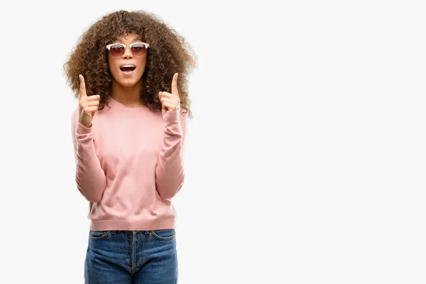 African American Woman Wearing Pink Sunglasses Amazed Surprised Looking Pointing — Stock Photo, Image