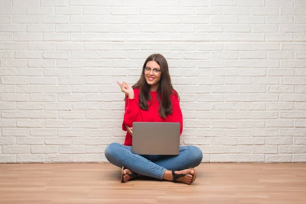 Jovem Morena Sentada Chão Sobre Parede Tijolo Branco Usando Laptop — Fotografia de Stock