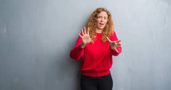 Young Redhead Woman Grey Grunge Wall Wearing Red Sweater Afraid — Stock Photo, Image