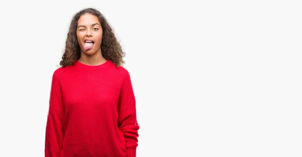 Young Hispanic Woman Wearing Red Sweater Sticking Tongue Out Happy — Stock Photo, Image