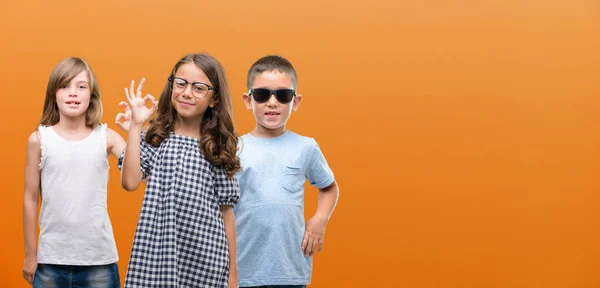 Grupo Niños Niñas Niños Sobre Fondo Naranja Haciendo Signo Con —  Fotos de Stock