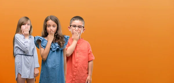 Jongen Meisjes Groep Kinderen Oranje Achtergrond Dekking Mond Met Hand — Stockfoto