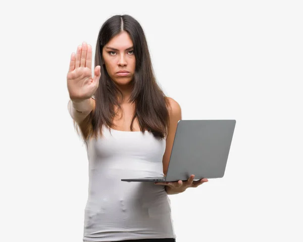 防衛ジェスチャー 深刻な自信を持って式に一時停止の標識を行うオープン手でラップトップ コンピューターを使用して若いヒスパニック系女性 — ストック写真