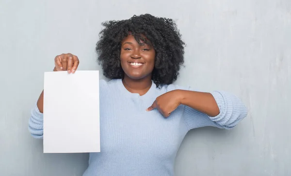 Unga Afroamerikanska Kvinnan Över Grå Grunge Väggen Håller Tomt Papper — Stockfoto