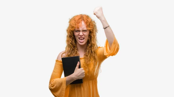 Young Redhead Student Woman Holding Book Annoyed Frustrated Shouting Anger — Stock Photo, Image