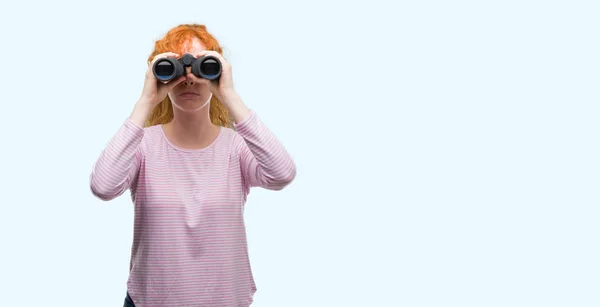 年轻的红头发的女人看着望远镜与自信的表情 聪明的脸认真思考 — 图库照片