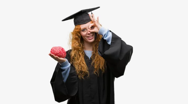 Giovane Studentessa Rossa Con Indosso Uniforme Graduata Che Tiene Cervello — Foto Stock