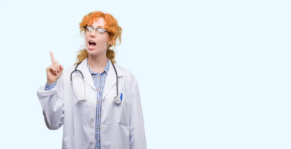 Young Redhead Woman Wearing Doctor Uniform Pointing Finger Successful Idea — Stock Photo, Image