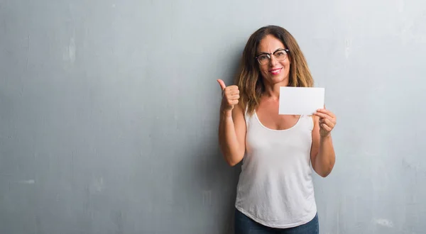 Mujer Hispana Mediana Edad Pie Sobre Pared Grunge Gris Sosteniendo —  Fotos de Stock