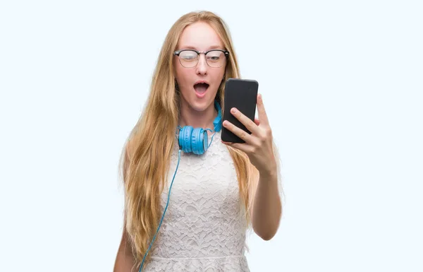 Mulher Adolescente Loira Segurando Smartphone Usando Fones Ouvido Assustados Choque — Fotografia de Stock