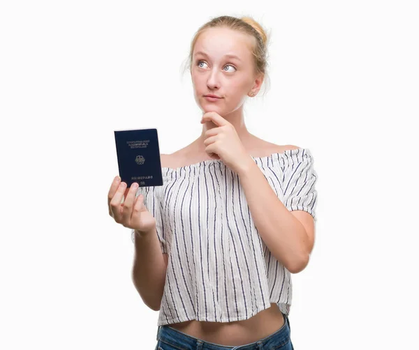 Mulher Adolescente Loira Segurando Passaporte Alemanha Rosto Sério Pensando Questão — Fotografia de Stock