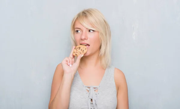 Caucasian Adult Woman Grey Grunge Wall Eating Chocolate Cooky Confident — Stock Photo, Image