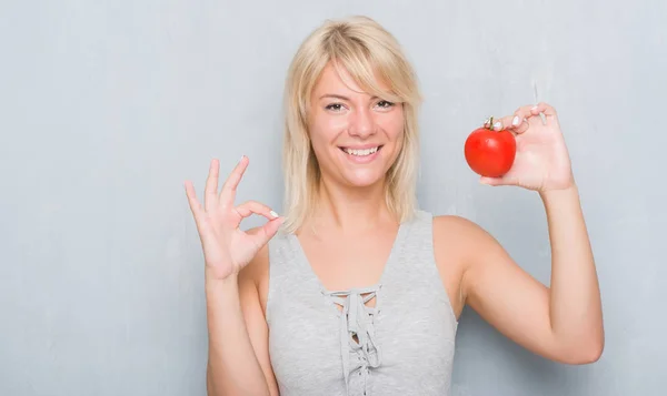 Adulto Mulher Caucasiana Sobre Grunge Parede Cinza Segurando Tomate Fresco — Fotografia de Stock